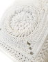 Close-up of intricate 3D sunburst crochet stitching in white Klim yarn.