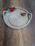 Round handmade jute rope tray with red fabric roses and handles.