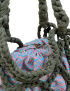 Dark olive green mesh crochet bag with braided handles and a patterned fabric inner sack.