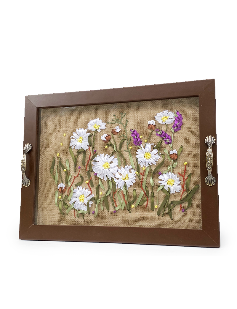 Front view of a wooden tray with white and purple ribbon-embroidered flowers on burlap.