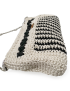 Perspective view of a beige and black crochet handbag showing textured stitching.