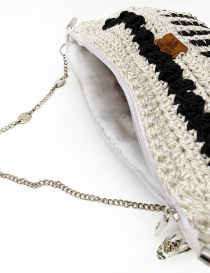 Open handbag showing white fabric inner lining and secure zipper closure.