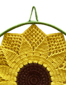 Top view of the crochet sunflower showing the hanging loop and intricate stitch work.