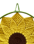 Top view of the crochet sunflower showing the hanging loop and intricate stitch work.