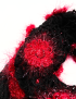 Macro view of a fuzzy red rose crochet square and black lace stitching.