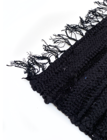 Close-up texture of woven recycled black textile and fringe detail.