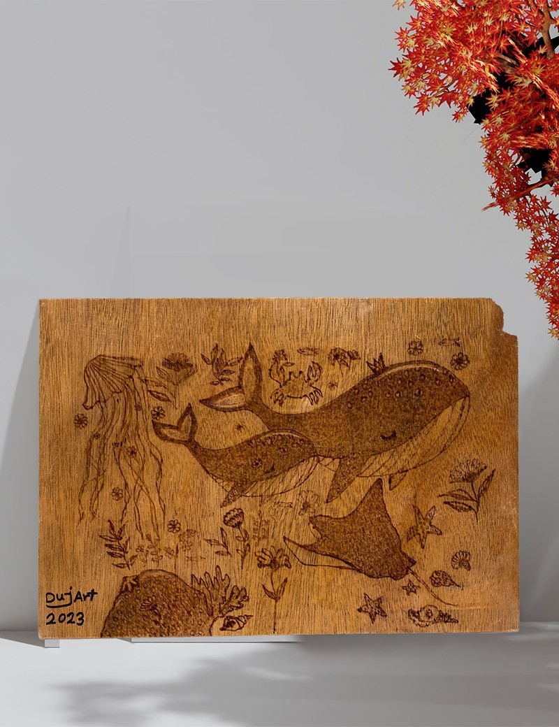 Marine life pyrography artwork displayed on a wall.