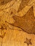 Macro detail of a woodburned stingray and starfish.