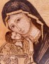 Detailed closeup of pyrography technique on Virgin Mary's face.