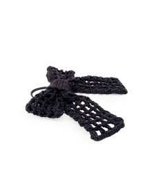 Angled view of a handmade black crochet bow showing texture and elastic tie.