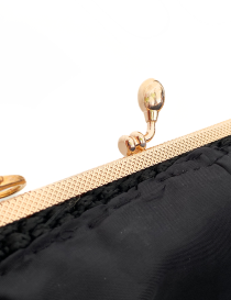 Detail of the gold-tone textured metal frame on a black bag.