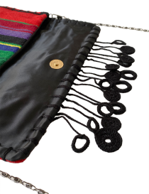 Close-up of black artisanal edge stitching on red wool.