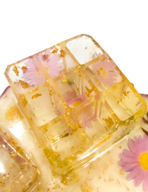 Detailed view of square resin accessory cup and floral tray base.