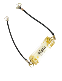 Custom resin name bracelet featuring "Hala" in black script with gold leaf flakes.