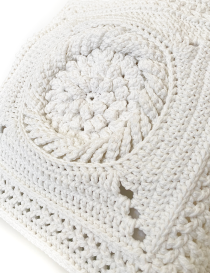 Close-up of intricate 3D sunburst crochet stitching in white Klim yarn.