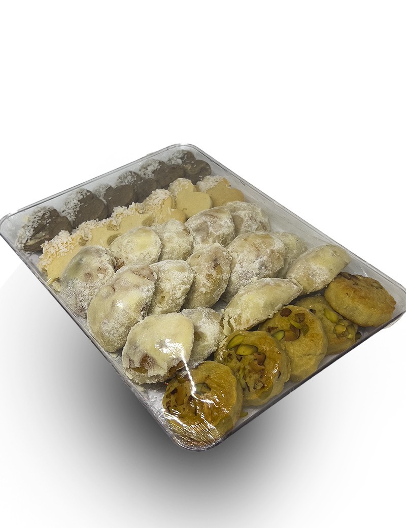 Assorted round tray of pistachio and coconut-topped traditional petit fours.