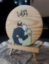 Hand-painted wood slice with hugging couple illustration and Arabic text "You are my everything" on easel.