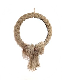 Round wall mirror with braided jute rope frame and beaded tassel bow.