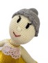 Close-up of a handmade crochet doll with grey hair bun and lace collar.