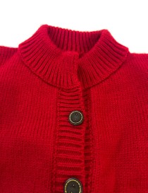 Closeup to handmade red knitted cardigan for girls with buttons and ribbed collar.