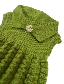 Girls' handmade green sleeveless knitted dress with textured skirt and swan brooch.