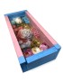 Crimson blue-pink wooden gift box with a "He or She?" candle and floral wax decorations for a baby gender reveal.