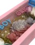 Crimson blue-pink wooden gift box with a "He or She?" candle and floral wax decorations for a baby gender reveal.