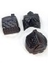 Three dark chocolate treats molded into highly detailed shapes of miniature houses in paper liners.