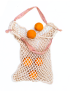 Beige cotton crochet net market bag with pink chevron handles containing oranges.