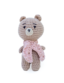 Hand-crocheted beige amigurumi teddy bear wearing a pink knit scarf.