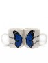 Pair of white ceramic mugs with a blue butterfly design and Arabic calligraphy.