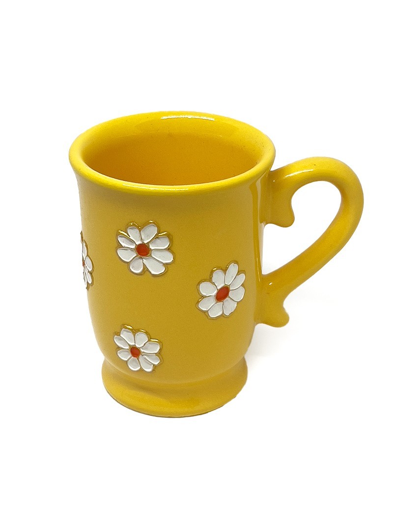 Hand-painted yellow ceramic mug with white daisy floral design and decorative handle.