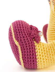 Detailed macro shot of the purple crochet foot with a yellow stripe and pearl-accented flower.