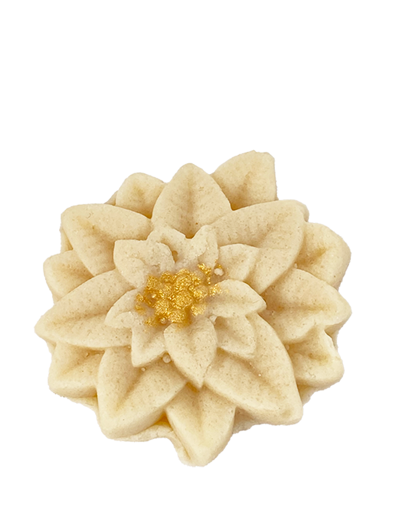 A close-up of a single, highly detailed almond marzipan flower with a shimmering gold-dusted center.
