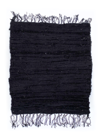 Flat lay of a hand-loomed recycled black fabric rug with fringe.