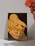 Pyrography wood-burning art of hands holding a child on A4 wood panel.