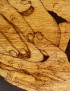 Detailed wood grain and hand-etched linework of pyrography art.