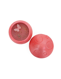 Top view of open mushroom candle showing pink wax, glitter, and wax butterfly.