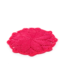 Close-up side view of handmade fuchsia crochet teapot mat.