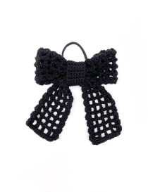 Top-down view of a black crochet ribbon bow hair tie with mesh pattern.