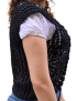 Side view of a handmade black open-knit vest showing the armhole and shell stitch detail.