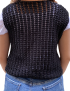 Back view of a woman wearing a black crochet vest showing the intricate knit pattern.