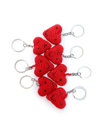 A collection of seven handmade red crochet heart keychains with smiling faces.