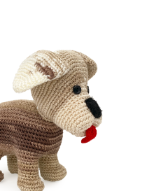 Close-up of an amigurumi dog face showing a black nose and floppy ear details.
