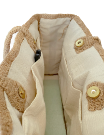 Close-up of the bag's reinforced bottom featuring four protective gold metal feet.