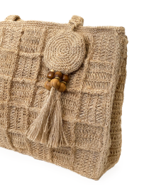 Close-up of the decorative circular crochet charm with wooden beads and jute tassel.
