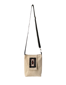 Front view of Palmyra beige linen crossbody bag with beaded motif.