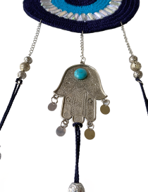 Close-up of the silver Hamsa hand charm with a turquoise stone and dangling metal coins.