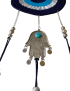Close-up of the silver Hamsa hand charm with a turquoise stone and dangling metal coins.