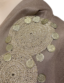 Macro shot of the intricate handmade crochet circle work with gold-toned thread.